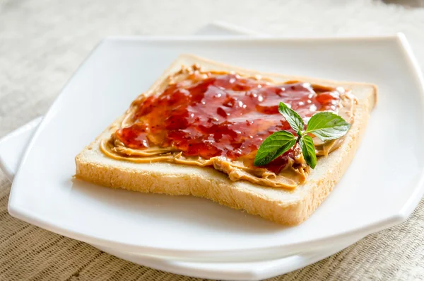 Boterham met pindakaas en strawberry jam — Stockfoto