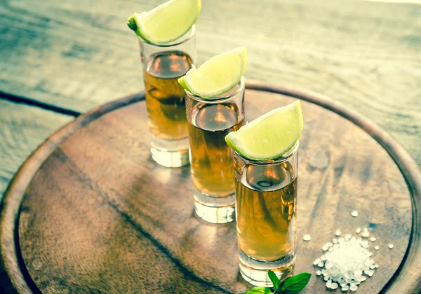 Glasses of tequila on the wooden board — Stock Photo, Image