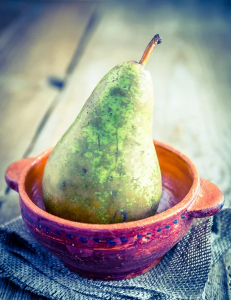 Green pear in rustic decor — Stock Photo, Image