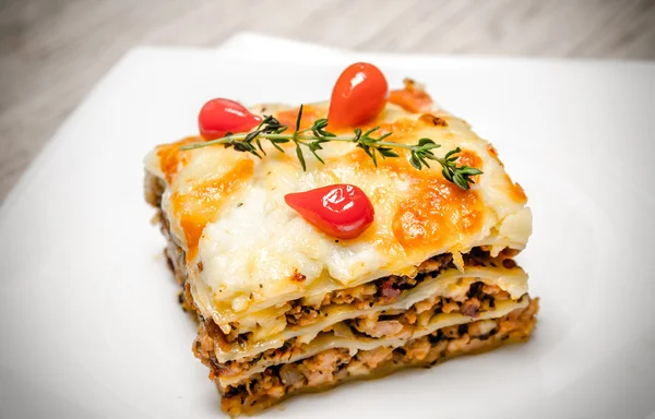 Portion of lasagna on the square plate — Stock Photo, Image