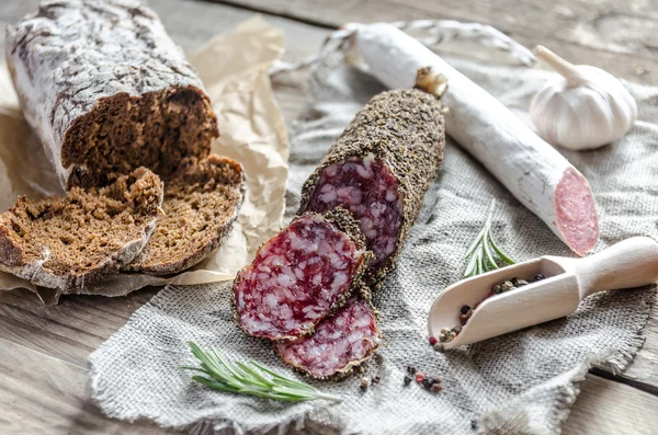 Szelet saucisson és a a zsákvászon spanyol szalámi — Stock Fotó