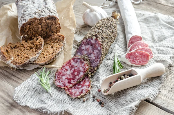 Scheiben Saucisson und spanische Salami auf dem Sacktuch — Stockfoto