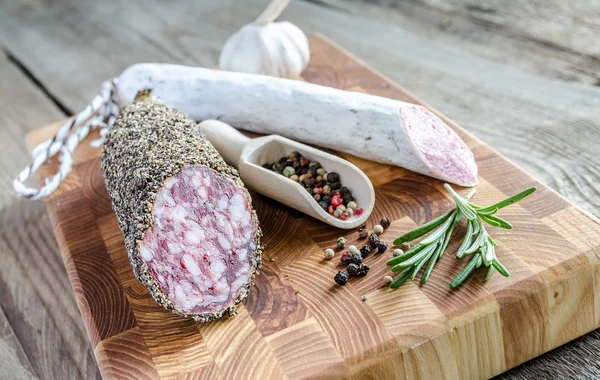 Saucisson and spanish salami on the sackcloth — Stock Photo, Image