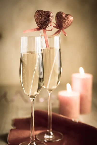 Glas champagne i med levande ljus på St Valentine's day — Stockfoto