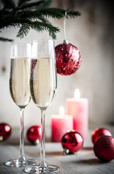 Glas champagne under dekorerad julgran gren — Stockfoto