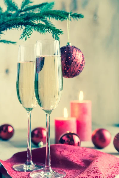 Glas champagne under dekorerad julgran gren — Stockfoto