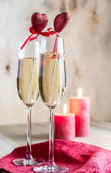 Glas champagne i med levande ljus på St Valentine's day — Stockfoto