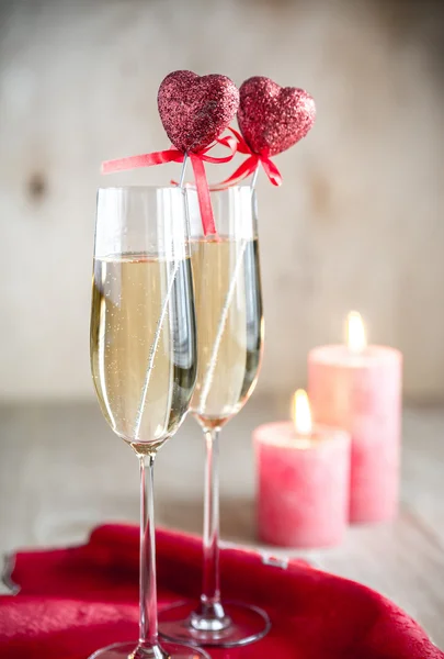 Glas champagne i med levande ljus på St Valentine's day — Stockfoto