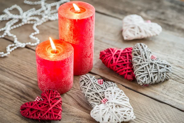 Corazones con velas encendidas en el fondo de madera — Foto de Stock