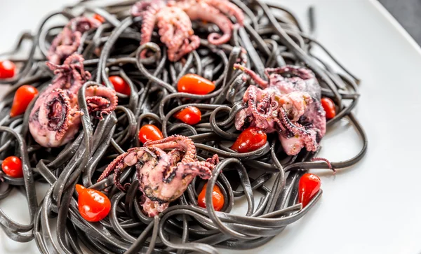 Pasta met zwarte inktvis inkt en kleine octopussen — Stockfoto