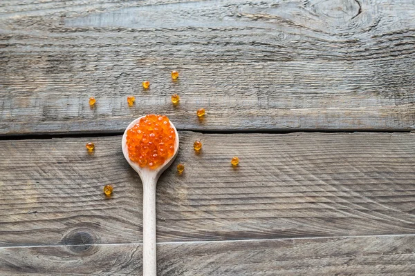 Scoop of red caviar on the wooden background — Stock Photo, Image