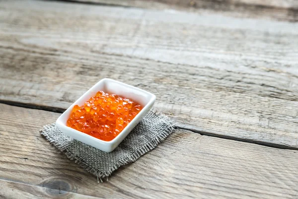 Kom van rode kaviaar op de houten tafel — Stockfoto