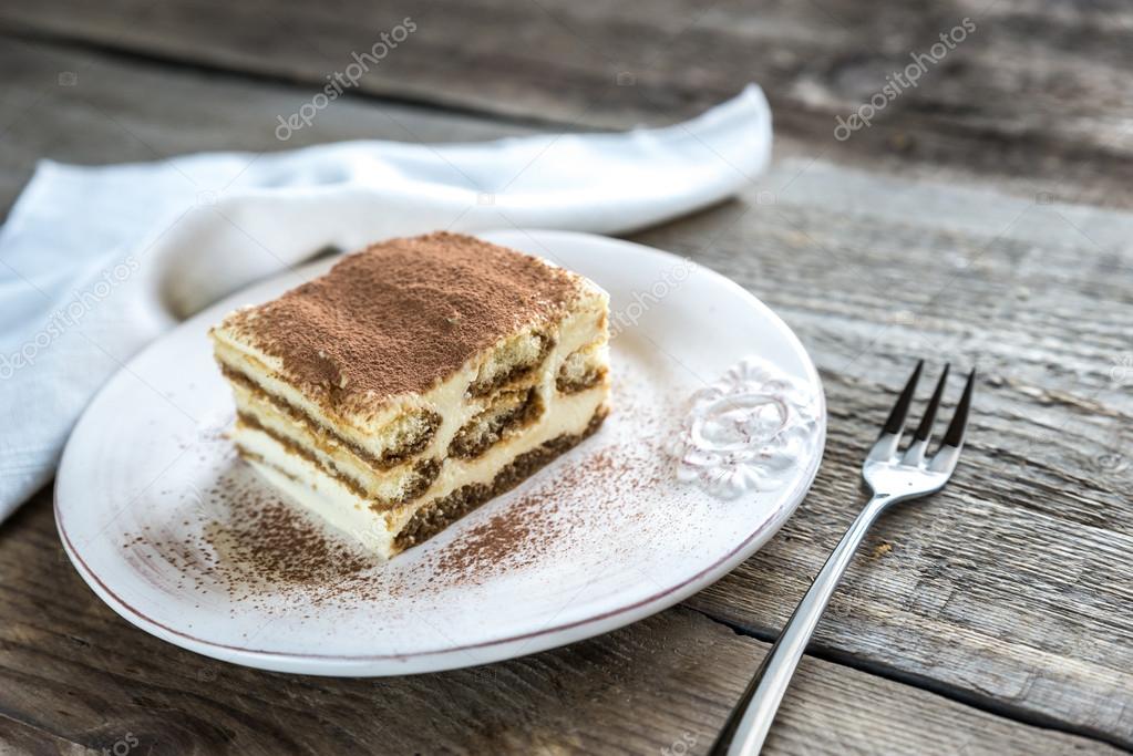 Tiramisu on the plate on the wooden background