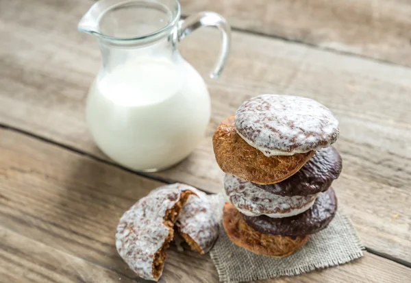 Glazed gingerbread cakes with pitcher of milk — Stock Photo, Image