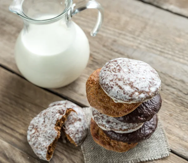 Glazed gingerbread cakes with pitcher of milk — Stock Photo, Image