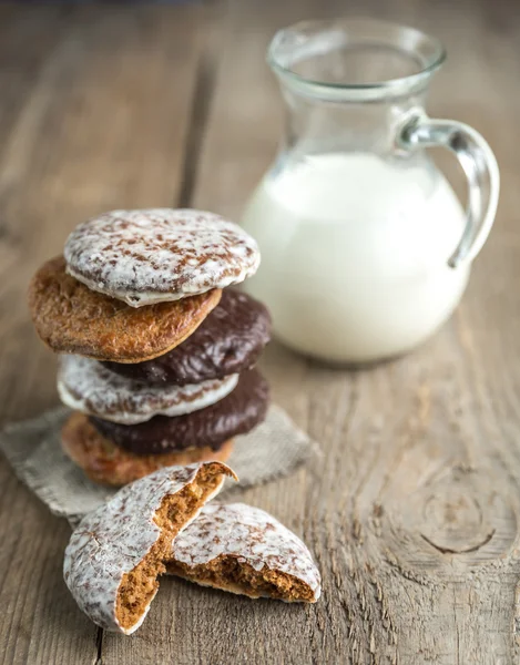 Glazed gingerbread cakes with pitcher of milk — Stock Photo, Image