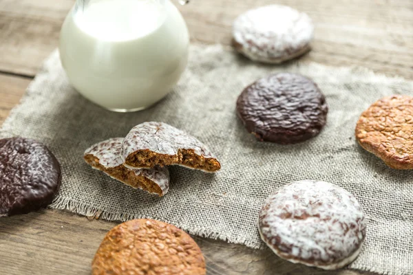 Glazed gingerbread cakes with pitcher of milk — Stock Photo, Image