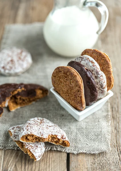 Glazed gingerbread cakes with pitcher of milk — Stock Photo, Image