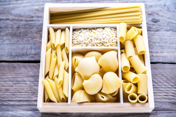 Various types of pasta in the wooden container — Stock Photo, Image