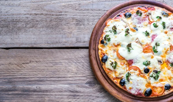 Cooked pizza on the wooden board — Stock Photo, Image