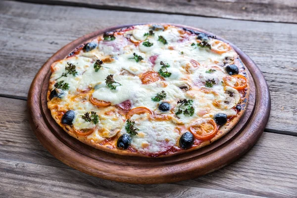 Cooked pizza on the wooden board — Stock Photo, Image