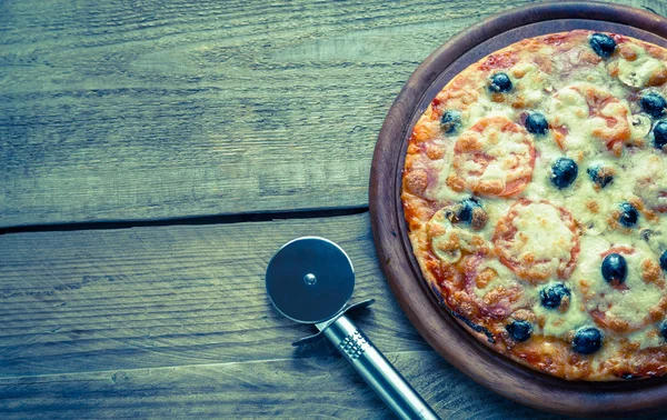 Ahşap tahta üzerinde pişmiş pizza — Stok fotoğraf