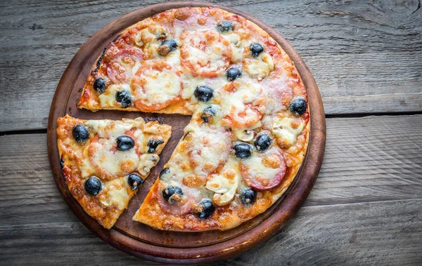 Cooked pizza on the wooden board — Stock Photo, Image