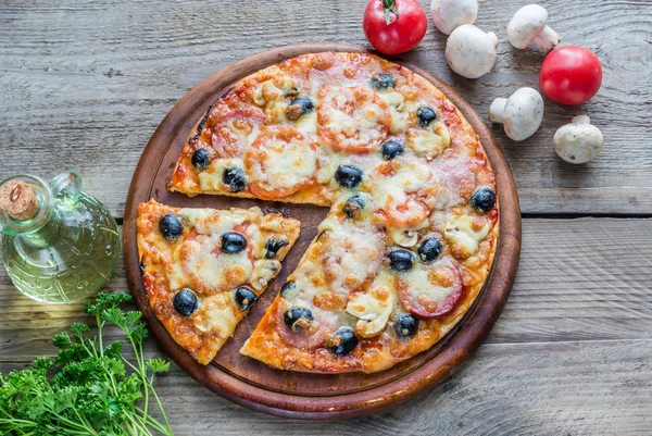 Ahşap tahta üzerinde pişmiş pizza — Stok fotoğraf