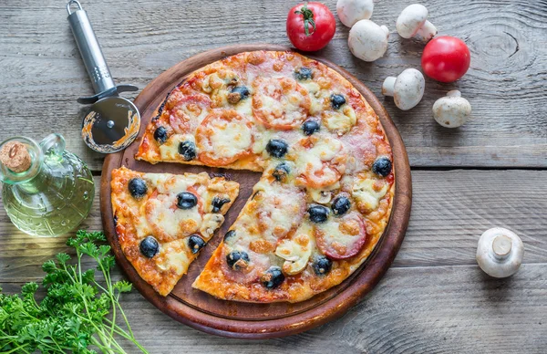 Ahşap tahta üzerinde pişmiş pizza — Stok fotoğraf