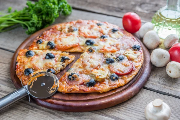 Cooked pizza on the wooden board — Stock Photo, Image