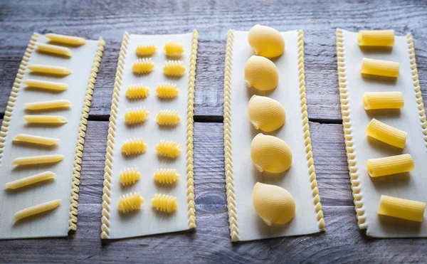 Verschillende soorten pasta op lasagne bladen — Stockfoto