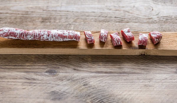 Snij Spaanse salami op de houten plank — Stockfoto