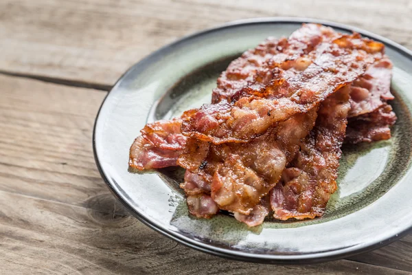 Stapel van gebakken bacon strips op de plaat — Stockfoto