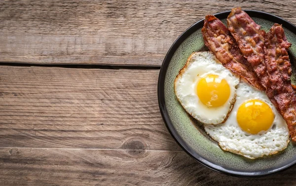 Portion of fried eggs with bacon — Stock Photo, Image