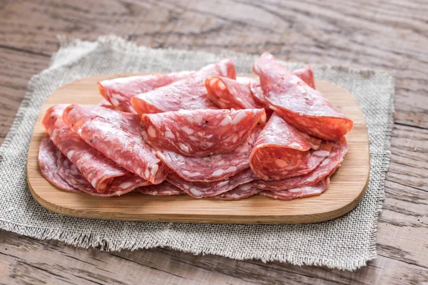 Slices of salami on the wooden board — Stock Photo, Image