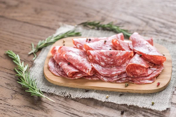 Slices of salami on the wooden board — Stock Photo, Image