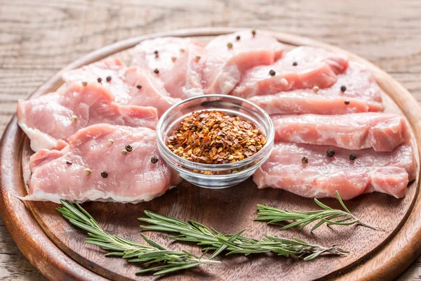 Raw pork steaks on the wooden board — Stock Photo, Image