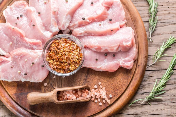 Ruwe varkensvlees steaks op de houten bord — Stockfoto