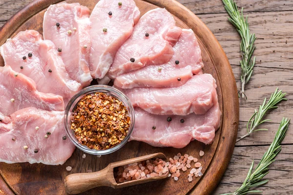 Raw pork steaks on the wooden board — Stock Photo, Image