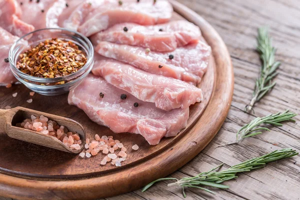 Raw pork steaks on the wooden board — Stock Photo, Image