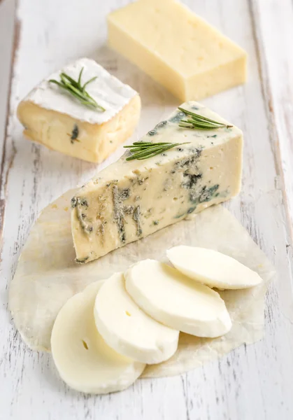 Various types of cheese on the wooden board — Stock Photo, Image