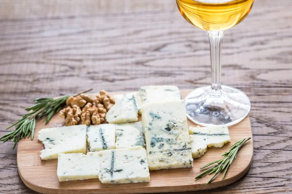 Roquefort com copo de vinho branco na tábua de madeira — Fotografia de Stock