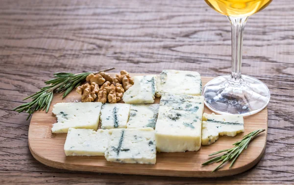 Roquefort com copo de vinho branco na tábua de madeira — Fotografia de Stock