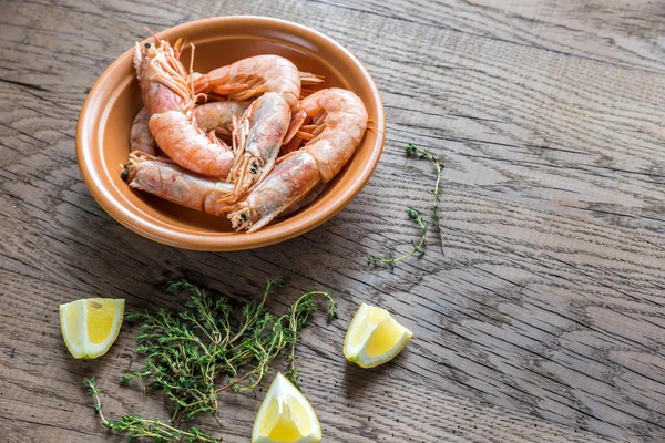Raw shrimps with lemon wedges — Stock Photo, Image