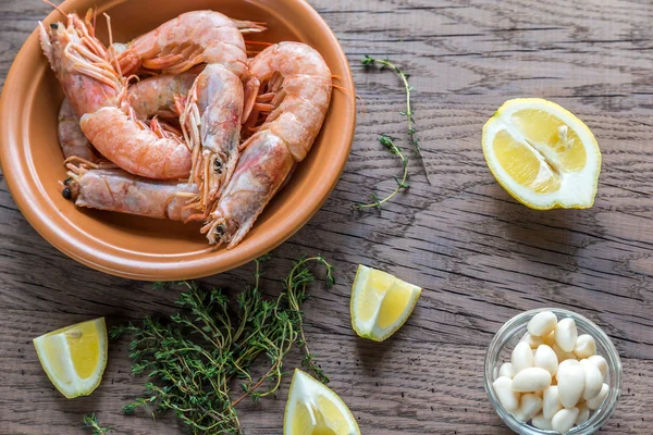 Raw shrimps with lemon wedges — Stock Photo, Image