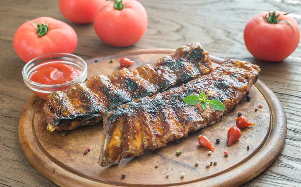 Grilled pork ribs with tomatoes on the wooden board — Stock Photo, Image