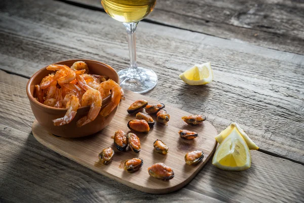 Crevettes frites et moules avec verre de vin blanc — Photo