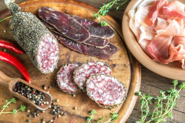 Dilim saucisson, jamon ve basturma ahşap tahta üzerinde