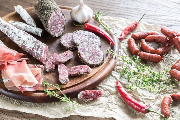 Different kinds of sausage on the wooden background — Stock Photo, Image