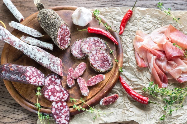 Different kinds of sausage on the wooden background — Stock Photo, Image